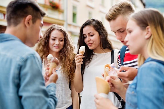 attractive-teenage-students-in-town-eating-ice-P53BHXE.jpg